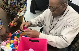 Man stuffing plastic Easter eggs